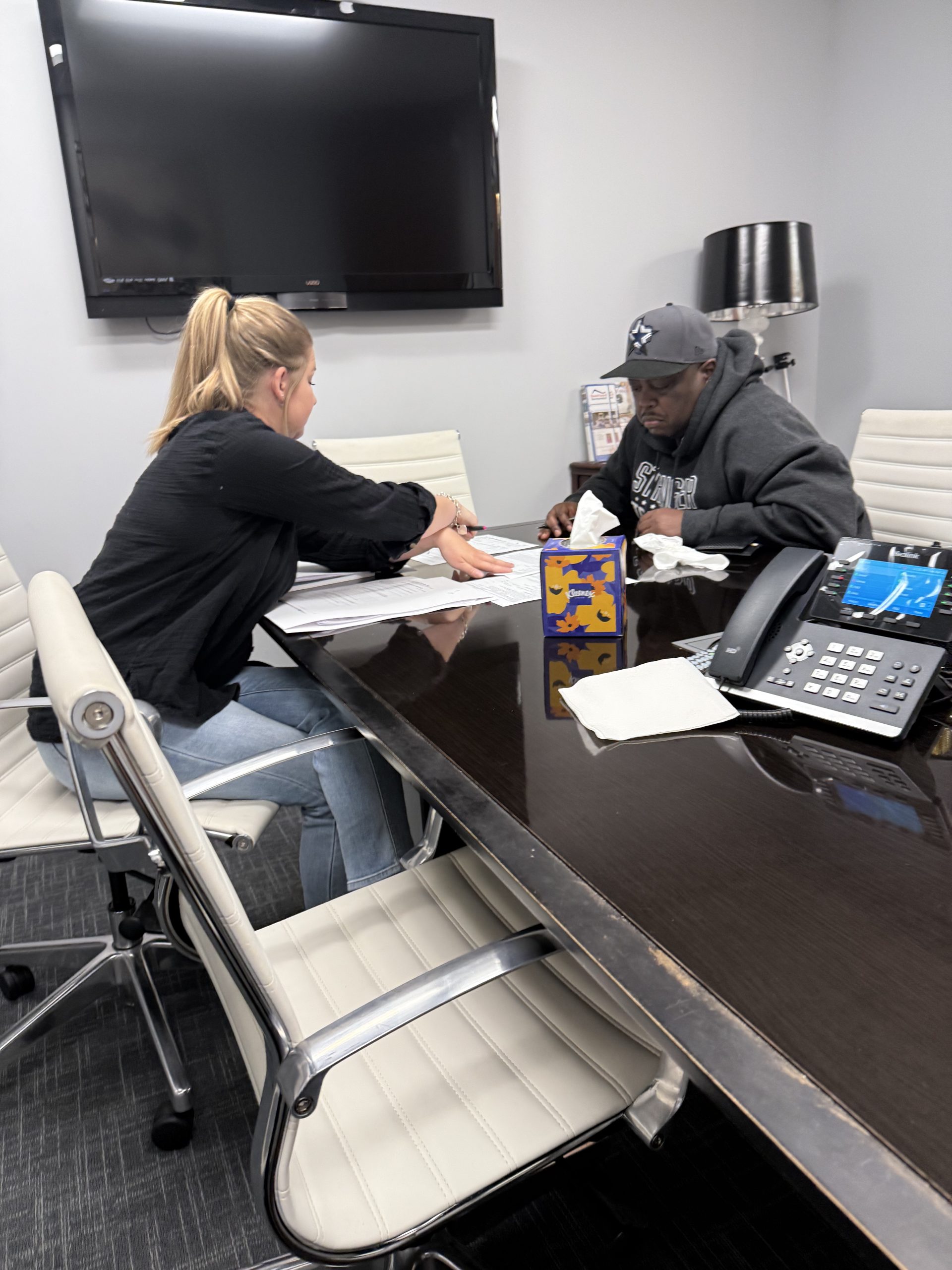 Tyrone signing at the closing table after selling his father's Los Angeles County house for cash