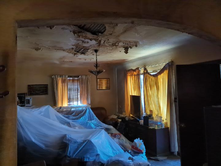Hoarder property living room packed with belongings in Tyrone's inherited California house
